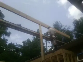 Carpenter setting a ridge beam over a new addition frame — Ice Dam Removal by Roofing Brothers in Amador City